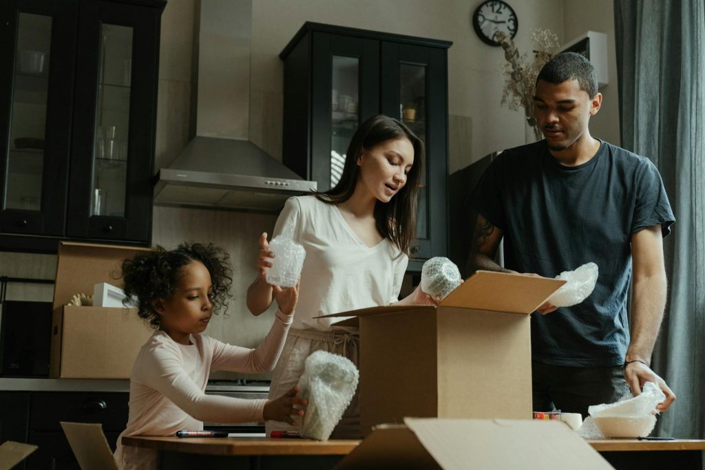 A family unpacks boxes in their new home kitchen, symbolizing a fresh start.